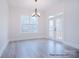 Bright, sunlit room with light hardwood floors, modern lighting fixture and view to outdoor deck at 122 Huntcliff Dr, Statesville, NC 28677