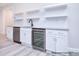 Wet bar area features white cabinetry, granite countertops, stainless appliances, and floating shelves at 122 Huntcliff Dr, Statesville, NC 28677