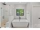 Bright bathroom features a soaking tub, glass-enclosed shower, and contemporary finishes at 127 Holt Ln, Mooresville, NC 28117
