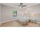 Bright bedroom features a ceiling fan, hardwood floors and a window overlooking trees at 127 Holt Ln, Mooresville, NC 28117