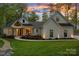 Inviting home exterior with well-manicured lawn, stone walkway, and modern architectural design, enhanced by a scenic sunset at 127 Holt Ln, Mooresville, NC 28117