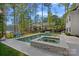 Relaxing pool and spa with elegant patio, landscaping, and lakeside views offer a backyard paradise at 127 Holt Ln, Mooresville, NC 28117