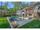 Beautiful backyard featuring a pristine pool, a cozy fire pit, and an elegant two-story home with a balcony at 127 Holt Ln, Mooresville, NC 28117