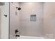 Modern shower with sleek subway tiles, black fixtures, and a built-in niche for storage at 127 Holt Ln, Mooresville, NC 28117