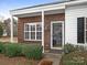 Close up of townhome's front brick facade, featuring a storm door and well-manicured front landscaping at 12954 Sickles Dr, Charlotte, NC 28273