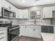This well-lit kitchen features stainless steel appliances, white cabinets, and laminate flooring at 12954 Sickles Dr, Charlotte, NC 28273