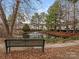 Community pond view, surrounded by beautiful trees and landscaping at 12954 Sickles Dr, Charlotte, NC 28273