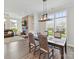 An open-concept dining area features hardwood floors, a stone fireplace, and a stylish chandelier above a dining table at 13702 Jacks Ln, Pineville, NC 28134