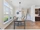 A dining room features a view of the neighborhood, modern lighting, and an elegant dining table at 13702 Jacks Ln, Pineville, NC 28134