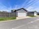 View of the detached two-car garage with white door, in a modern home at 13702 Jacks Ln, Pineville, NC 28134