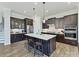 A well-equipped kitchen features dark wood cabinets, an island with seating, and stainless steel appliances at 13702 Jacks Ln, Pineville, NC 28134