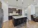 This kitchen features a large island with a white countertop, dark wood cabinets, and wood flooring at 13702 Jacks Ln, Pineville, NC 28134