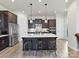 Stylish kitchen featuring a large island, stainless steel appliances, and dark wood cabinetry at 13702 Jacks Ln, Pineville, NC 28134