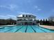 Large community pool featuring a modern design with a pool house and seating areas at 13702 Jacks Ln, Pineville, NC 28134