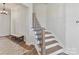 A staircase is accented with neutral colors and a wood and metal railing at 13702 Jacks Ln, Pineville, NC 28134