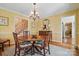 Elegant dining room featuring a round wooden table, chandelier, and views into the stairwell at 13916 & 13912 Sledge Rd, Charlotte, NC 28278