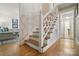 Elegant staircase featuring hardwood steps, white lattice railing, and decorative wallpaper, leading to the upper levels at 13916 & 13912 Sledge Rd, Charlotte, NC 28278