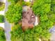 A bird's eye view shows the tree-lined property with a brick house featuring an elegant roof design at 15618 Eagleview Dr, Charlotte, NC 28278