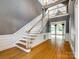Elegant foyer featuring gleaming hardwood floors, a staircase, and natural light streaming through large windows at 15618 Eagleview Dr, Charlotte, NC 28278