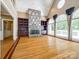 Spacious living room with a stone fireplace, built-in shelving, hardwood floors, and expansive windows at 15618 Eagleview Dr, Charlotte, NC 28278