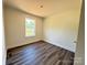 A bright bedroom boasts modern gray wood-look floors and trim with a view from the window at 159 Hallman St, Cherryville, NC 28021