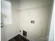 A small laundry area has hookups, a wire shelf and gray wood-look floors at 159 Hallman St, Cherryville, NC 28021