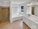 Bright bathroom featuring a double vanity, soaking tub, and glass-enclosed shower at 1625 Winthrop Ln, Monroe, NC 28110