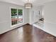 Bright dining room with hardwood floors, large window, and view to front entryway and staircase at 1625 Winthrop Ln, Monroe, NC 28110
