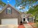 Charming two-story brick home with an attached garage and beautifully landscaped front yard at 1625 Winthrop Ln, Monroe, NC 28110