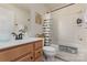 Neutral bathroom with wood cabinets, updated fixtures, and a shower/tub combo at 1720 Fleetwood Dr, Charlotte, NC 28208