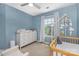 This Bedroom is decorated with a white dresser, a changing table, and a baby crib with a mobile at 1720 Fleetwood Dr, Charlotte, NC 28208