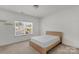 Bright bedroom with a modern bed frame and a view of the neighborhood through the window at 197 Park View Dr, Stanfield, NC 28163