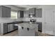 Modern kitchen boasts granite countertops, stainless appliances, gray cabinetry, and a functional center island at 197 Park View Dr, Stanfield, NC 28163