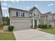 Traditional two-story home boasts attached two-car garage, manicured lawn, and covered front porch at 2014 Burton Point Ct, Waxhaw, NC 28173