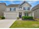 Charming two-story home with a well-manicured lawn, welcoming front porch, and an attached two-car garage at 2014 Burton Point Ct, Waxhaw, NC 28173