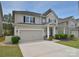 Inviting two-story home features a spacious driveway, attached garage, and a cozy front porch with manicured landscaping at 2014 Burton Point Ct, Waxhaw, NC 28173