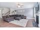 Open-concept living room with a fireplace, large sectional couch, and staircase leading to the upper level at 2014 Burton Point Ct, Waxhaw, NC 28173