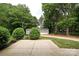 Spacious backyard with a concrete patio and a detached garage surrounded by lush greenery at 202 Hickory St, Locust, NC 28097