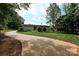 A home's exterior boasts a well-manicured lawn, complemented by lush greenery and mature trees at 202 Hickory St, Locust, NC 28097