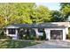Charming single-story home with a well-manicured lawn and a gray roof against a backdrop of lush trees at 202 Hickory St, Locust, NC 28097