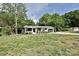 Home exterior featuring a well-manicured lawn, mature trees, and a charming covered front porch at 202 Hickory St, Locust, NC 28097