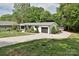 Charming home exterior featuring a long driveway, well-maintained lawn, and attached two-car garage at 202 Hickory St, Locust, NC 28097