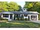 Beautiful one-story home featuring white painted brick, black trim, and manicured front yard landscaping at 202 Hickory St, Locust, NC 28097