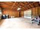 A spacious garage featuring exposed wooden beams, concrete flooring, and ample storage space at 202 Hickory St, Locust, NC 28097