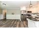 Open-concept kitchen with stainless steel appliances, white cabinets, and a breakfast bar at 202 Hickory St, Locust, NC 28097