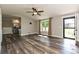 Bright living area featuring hardwood floors, a modern ceiling fan, and a large window at 202 Hickory St, Locust, NC 28097