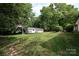 View of the detached shed and garage with an abundance of mature trees surrounding the property at 202 Hickory St, Locust, NC 28097