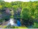 Aerial view of brick home near the pond and golf course, surrounded by lush greenery at 209 Tinkham Trl, Cramerton, NC 28032