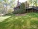 Backyard with brick exterior, large hedge and upper-level deck at 209 Tinkham Trl, Cramerton, NC 28032
