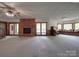 Spacious basement featuring a brick fireplace, french doors, built-in seating, and a ceiling fan at 209 Tinkham Trl, Cramerton, NC 28032
